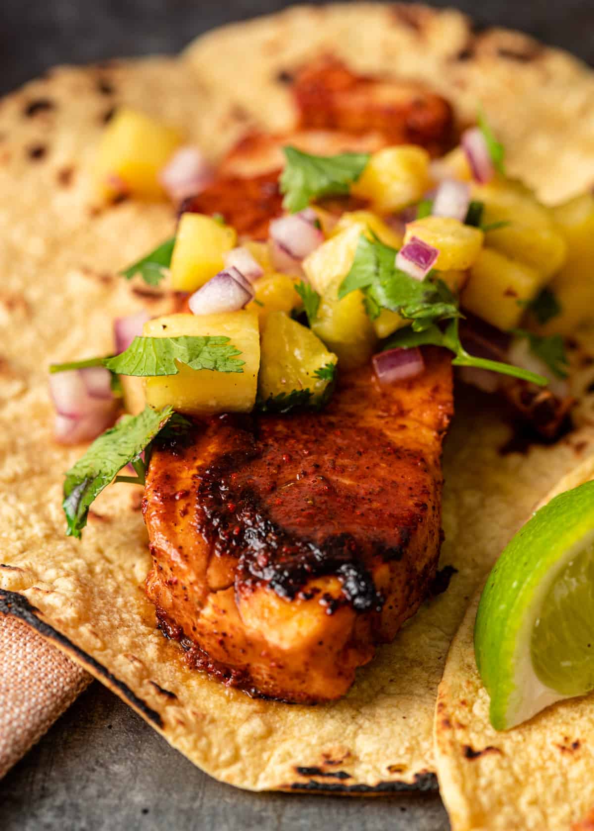 extreme closeup: tacos de pescado with pineapple salsa on top