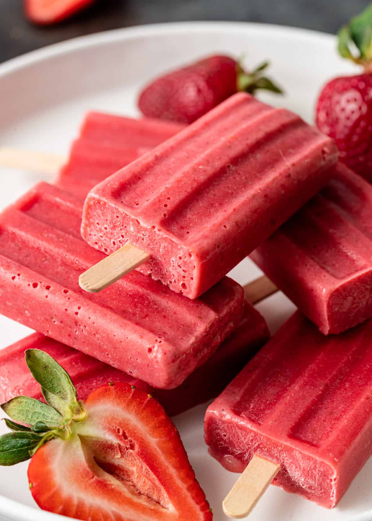 close up of strawberry and cream ice pops with fresh strawberries