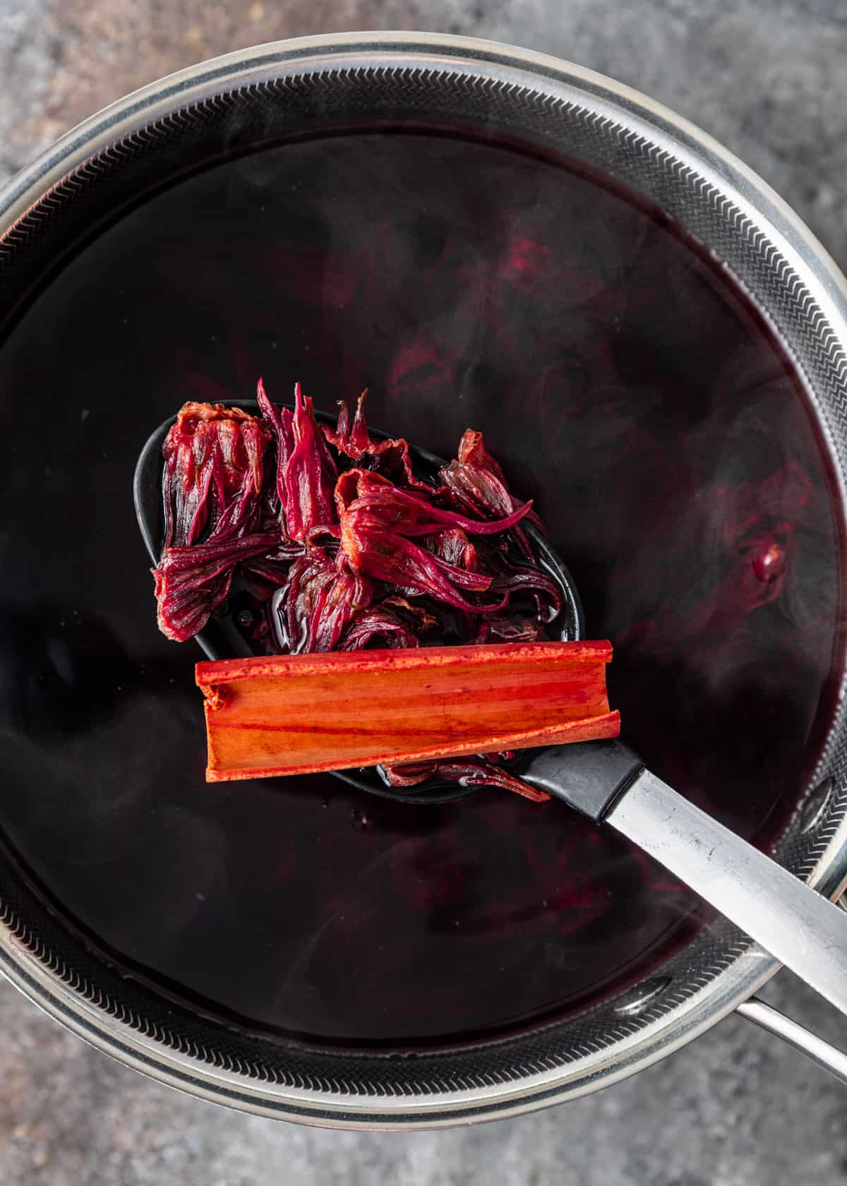 overhead: preparing the hibiscus in a saucepan with a large spoon