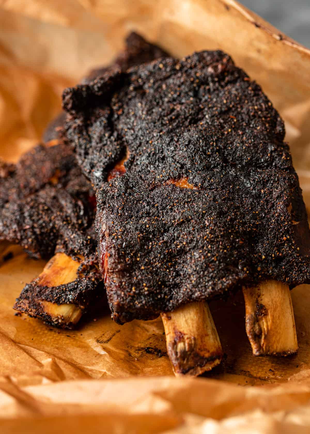 crispy and charred beef back ribs on a piece of parchment paper